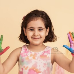 Happy Kid with colorful hands with paint